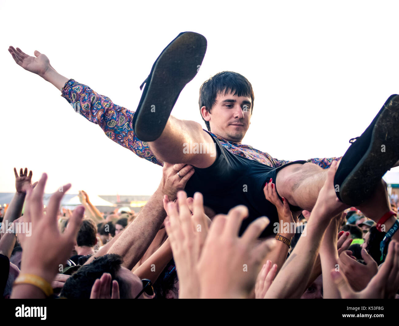 A young man crowd surfs over the audience at the Victorious music festival in Portsmouth, England Stock Photo
