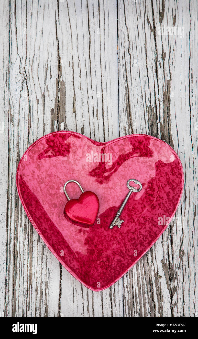 Red Heart dish with a heart lock and key to my heart concept with a gray weathered board backdrop, New Jersey, USA cut out, Saint Valentine day Stock Photo