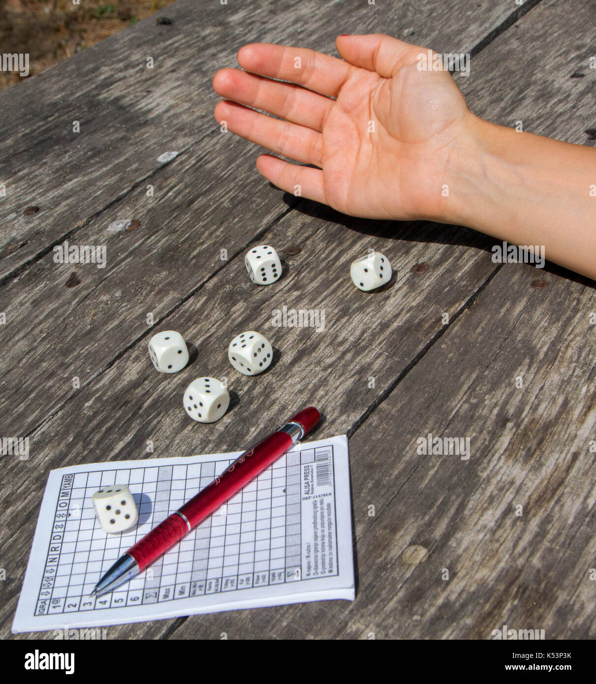 A woman's hand throws dice and plays a Yahtzee, dice game Stock Photo Alamy