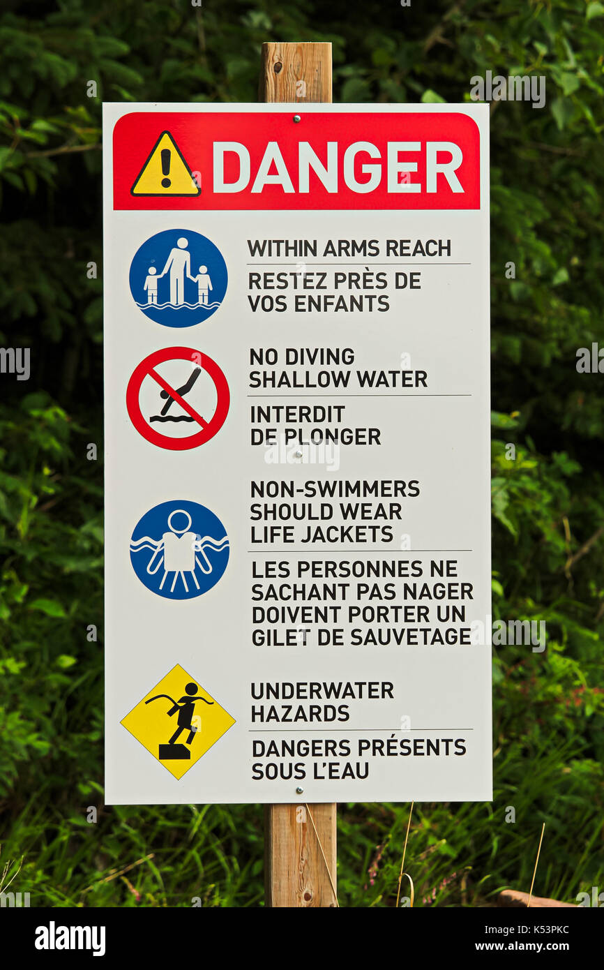 A danger sign with various beach rules on it Stock Photo Alamy