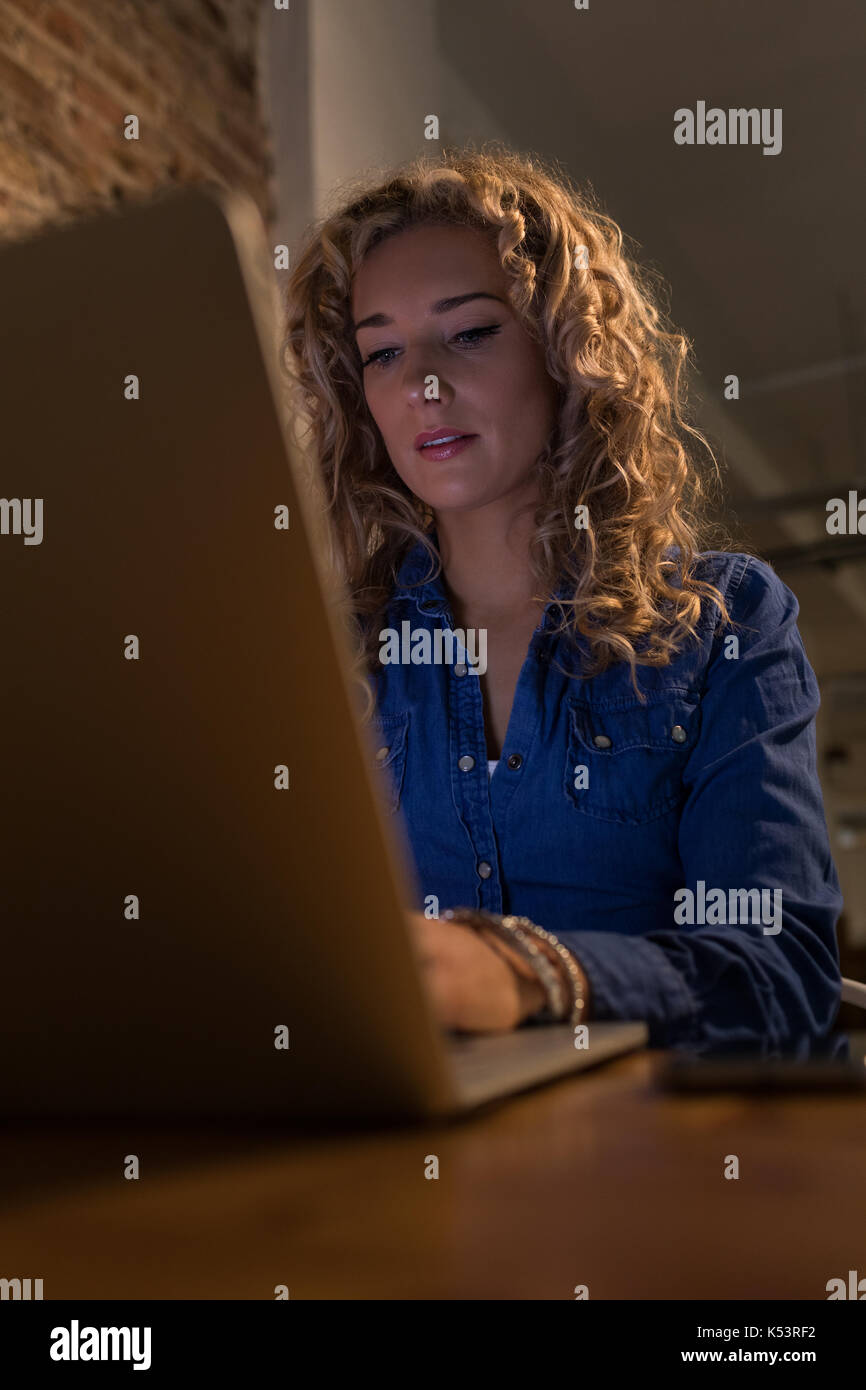 Woman using laptop computer at table in cafe Stock Photo