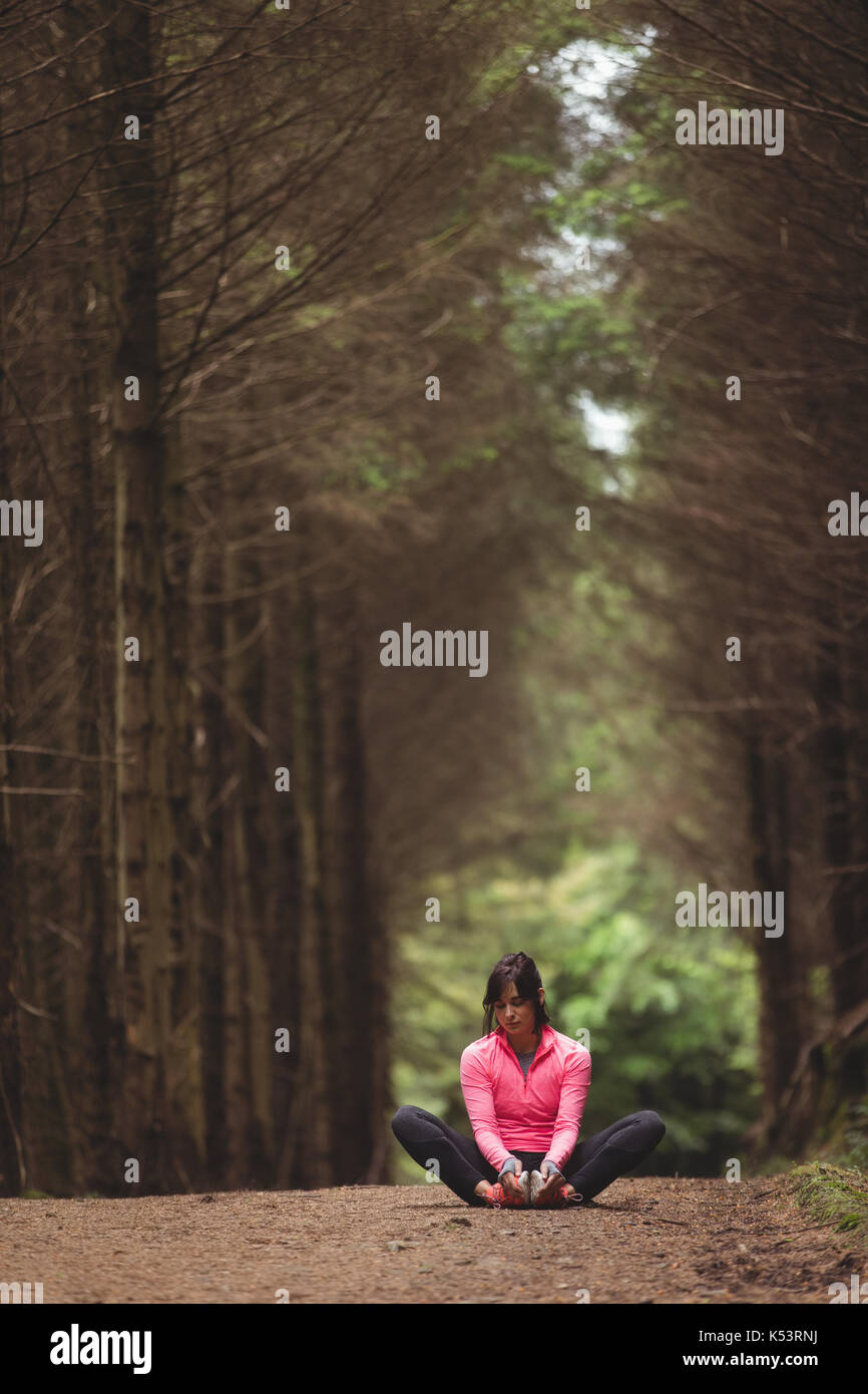 Woman performing stretching exercise in forest Stock Photo