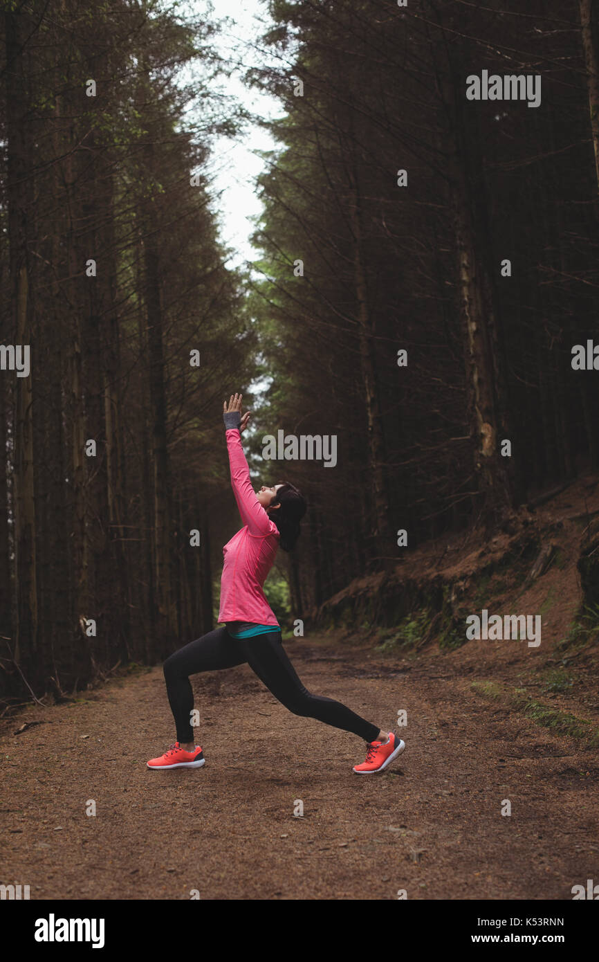 Woman performing stretching exercise in forest Stock Photo