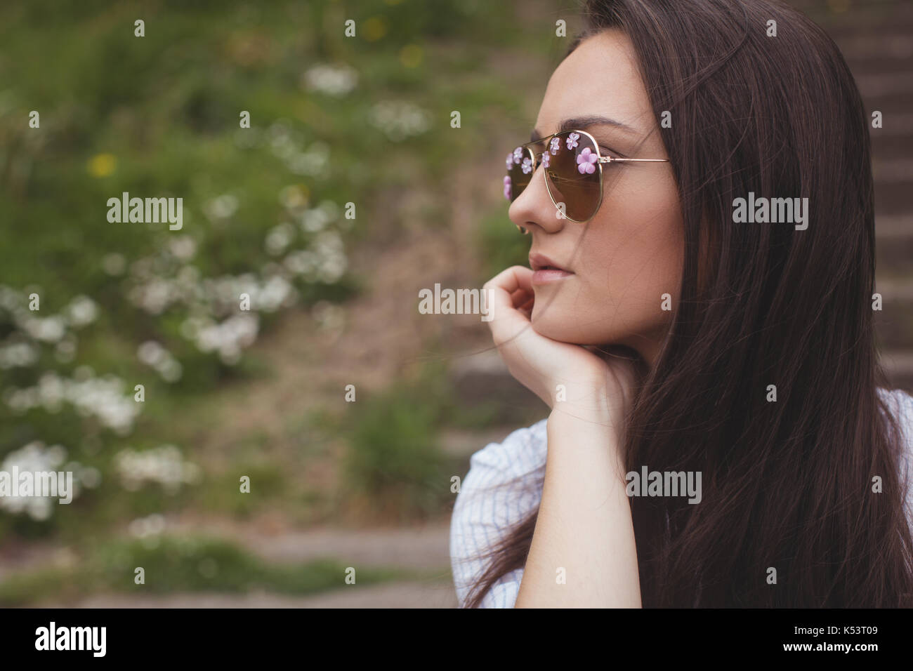 Thoughtful woman in sunglasses at forest Stock Photo