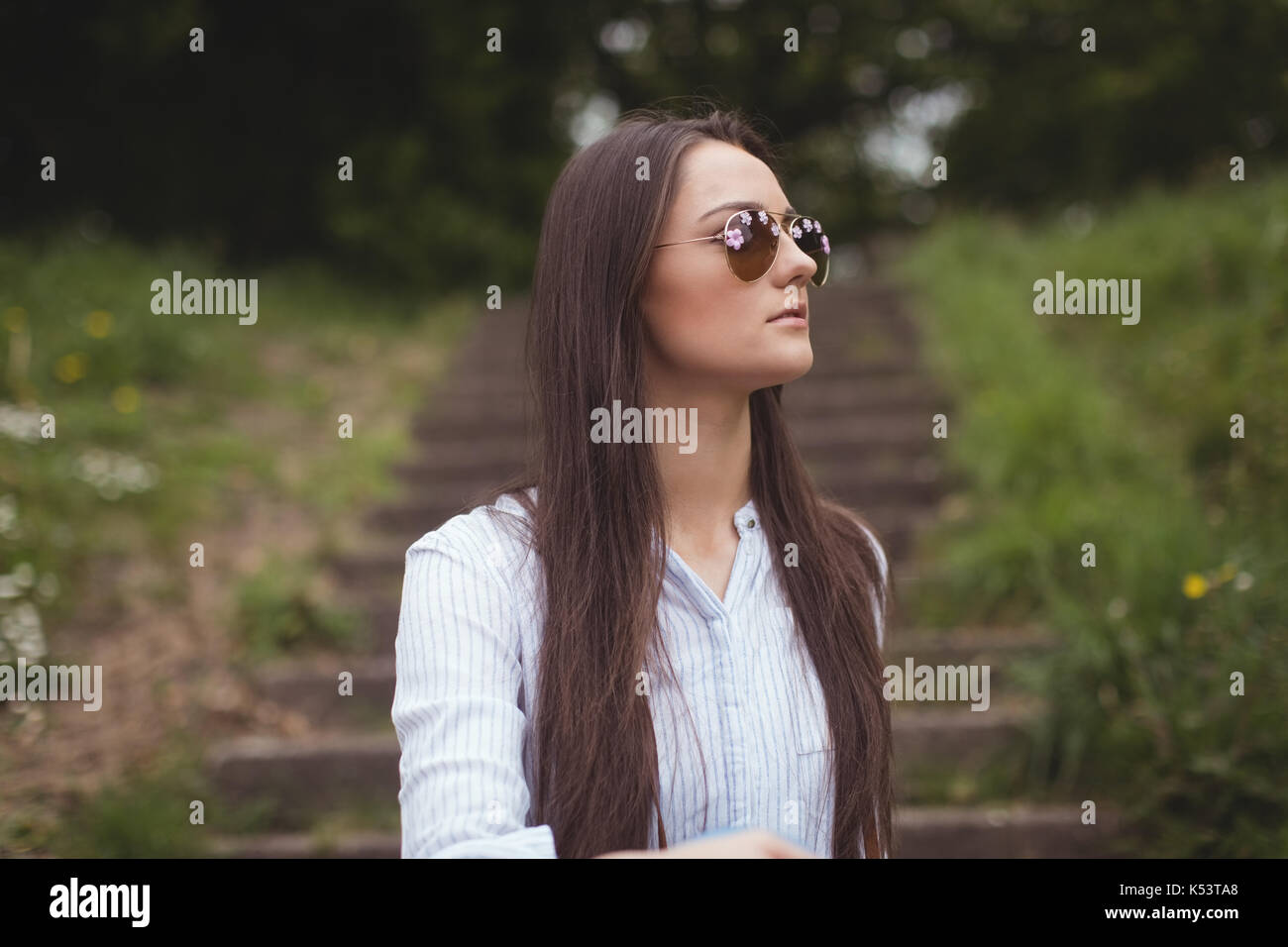 Thoughtful woman in sunglasses at forest Stock Photo