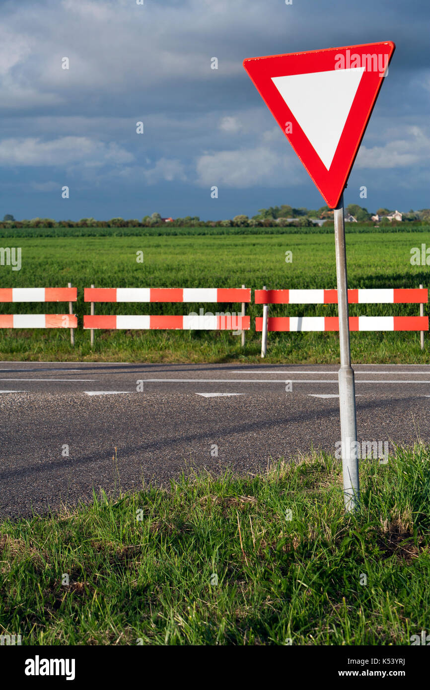 Dangerous T intersection with a road sign for give way priority yield road Stock Photo