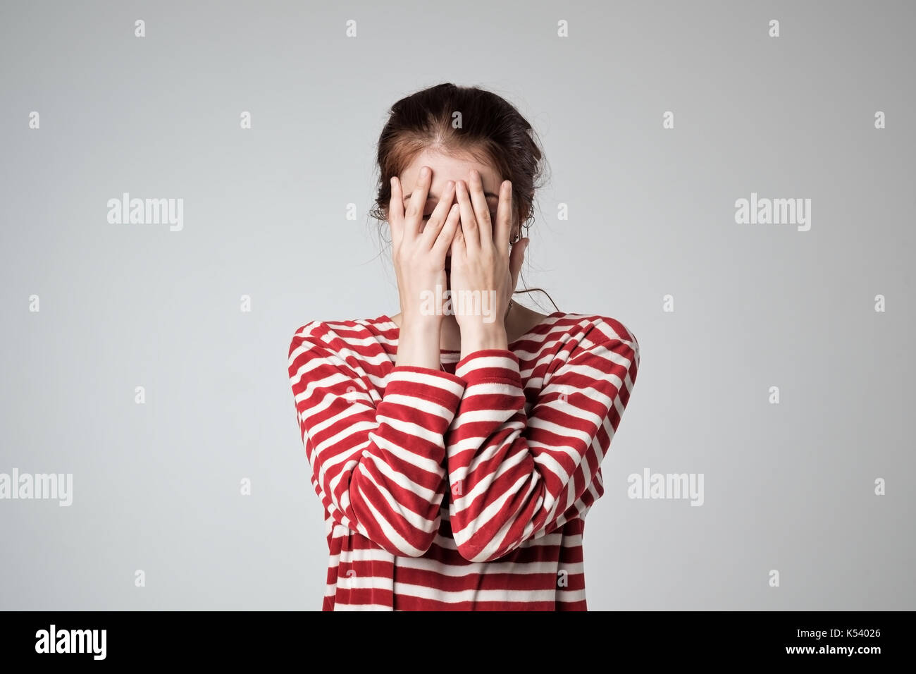 Pretty caucasian girl covers her face with her hands Stock Photo Alamy