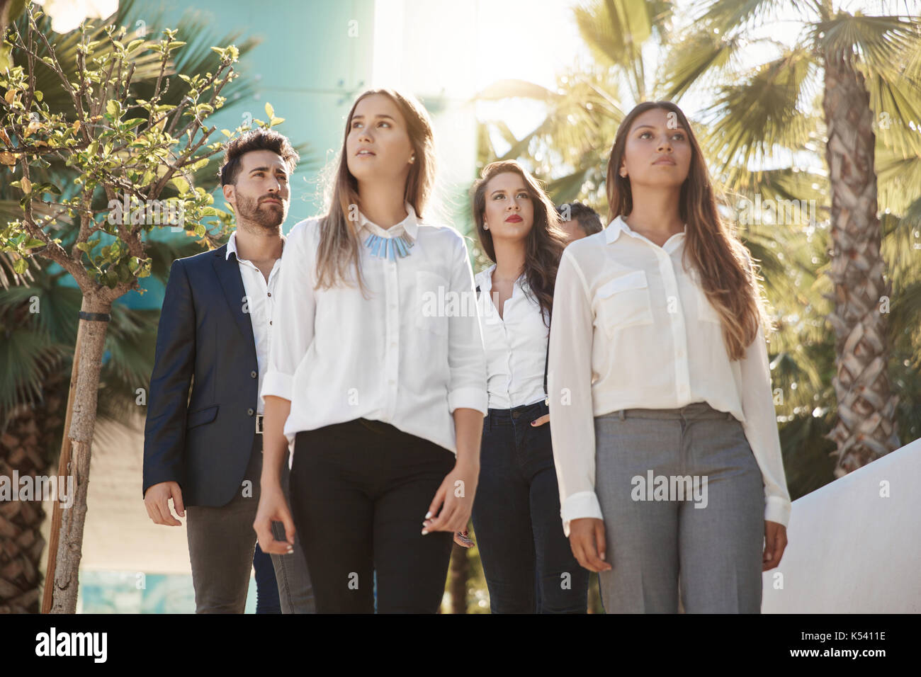 Portrait of beautiful businesswomen standing outside with coworkers Stock Photo