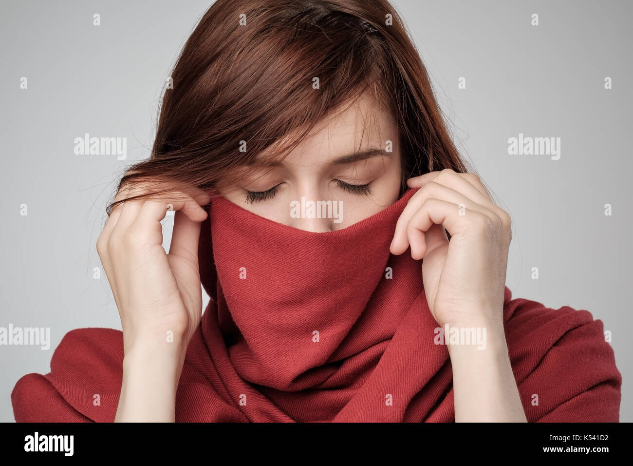 Portrait of red haired woman hiding face with scarf Stock Photo - Alamy