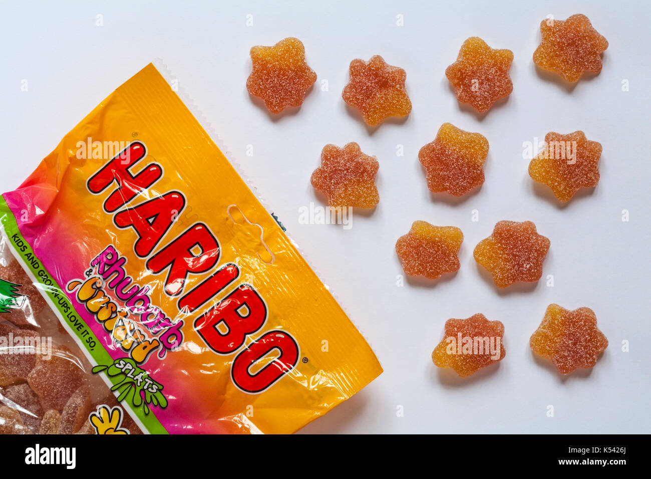 Packet of Haribo Rhubarb & Custard splats opened with contents spilled set on white background Stock Photo