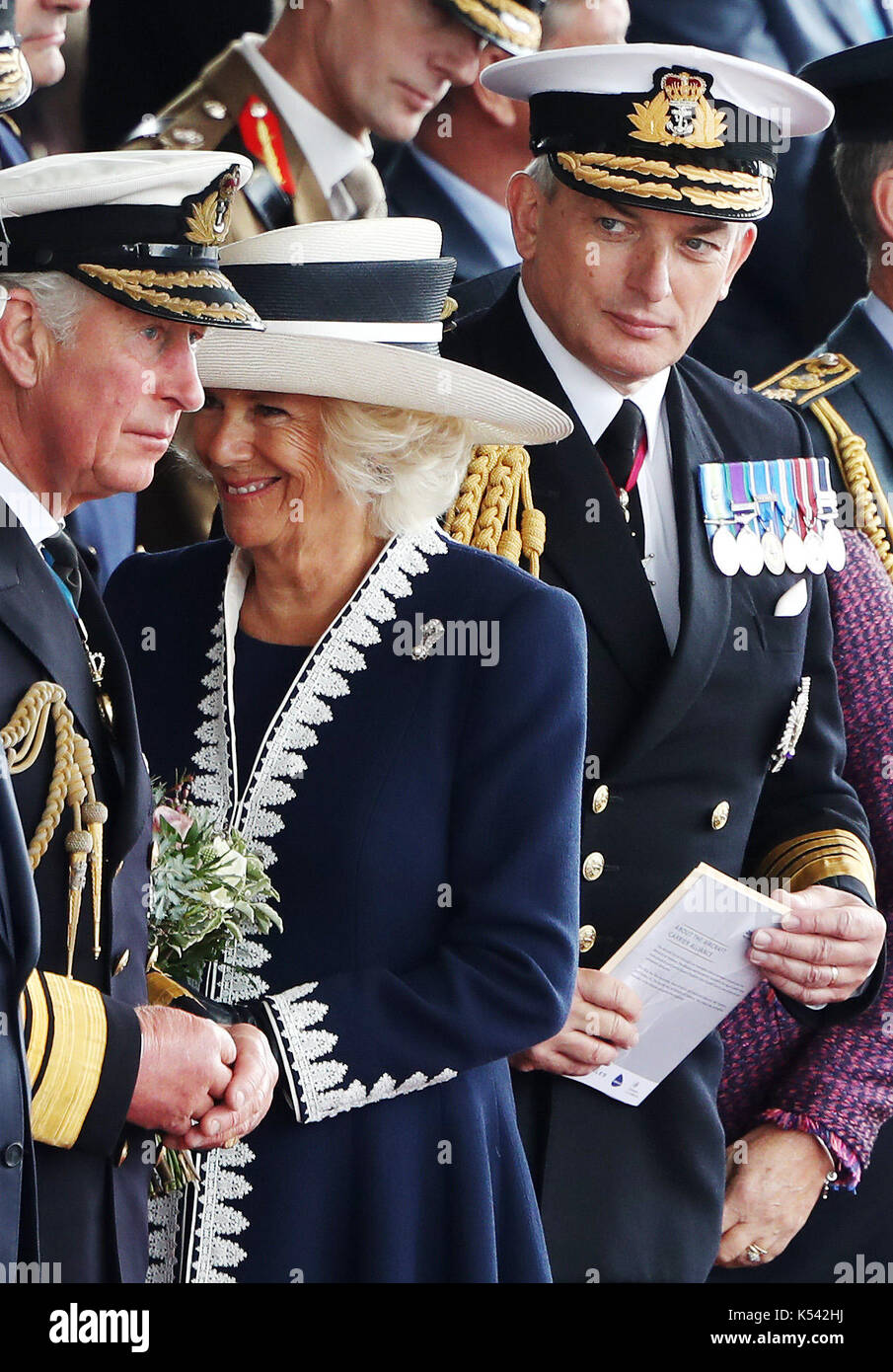 (Left-right) The Prince of Wales and the Duchess of Cornwall, known as the Duke and Duchess of Rothesay while in Scotland and First Sea Lord Admiral Sir Philip Jones during a naming ceremony of aircraft carrier HMS Prince of Wales at the Royal Dockyard in Rosyth. Stock Photo