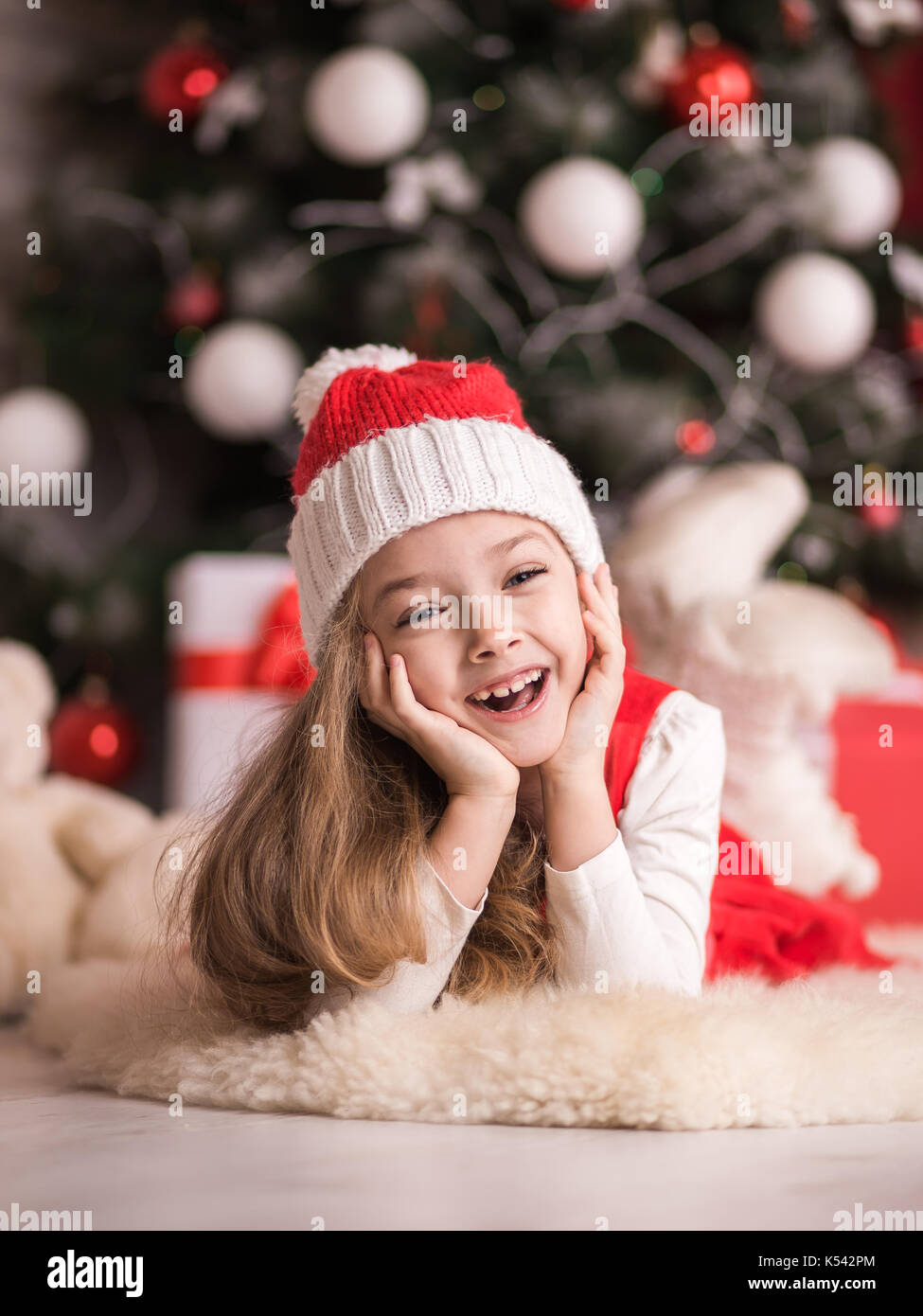 Portrait of a cute little girl on a christmas tree background, studio ...