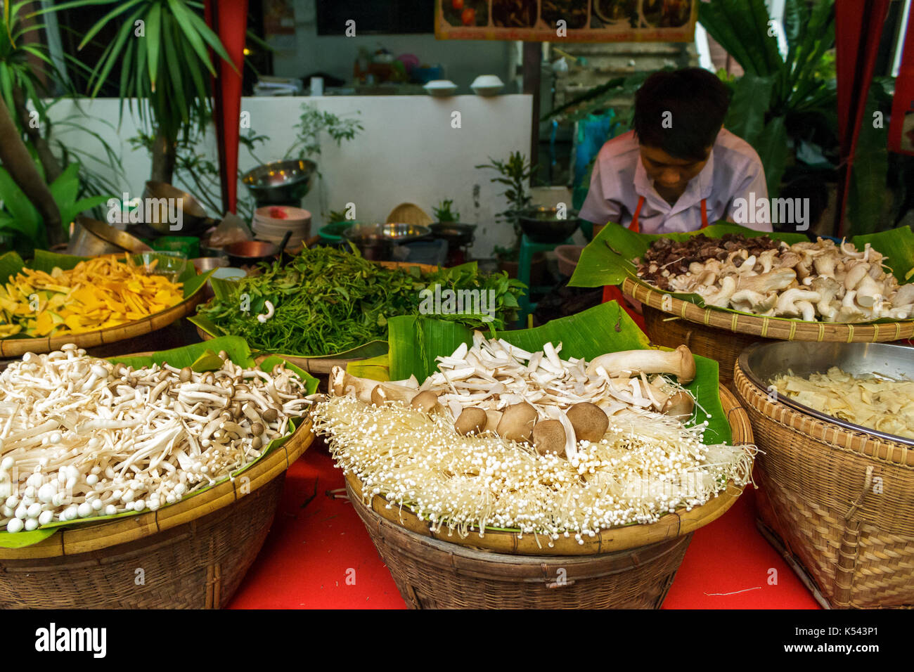 CHIANG MAI, THAILAND - 6/13/2015: A cook prepares vegetables for food at the Sunday walking street market. Stock Photo
