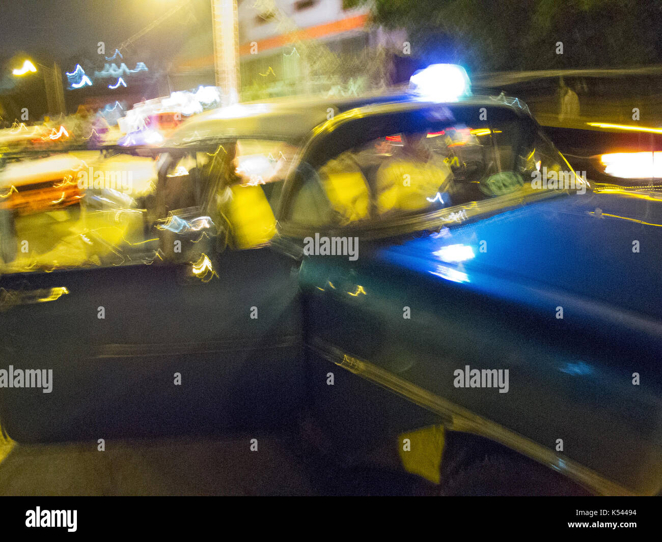 Out of focus image of a 1950's Cuban taxi at night in Havana, Cuba in the Caribbean. Stock Photo