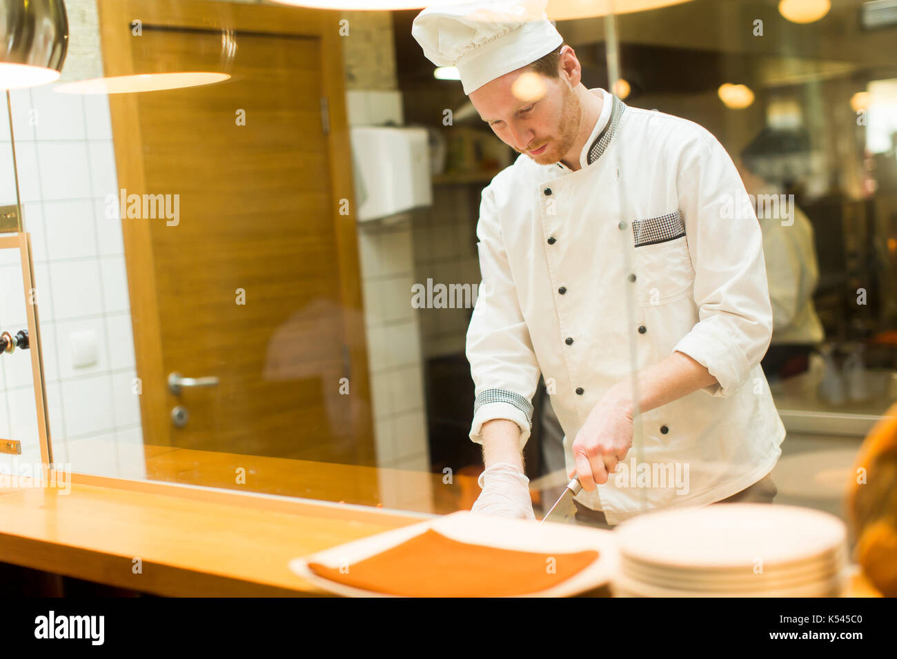 Young chef preparing food in the kitchen Stock Photo