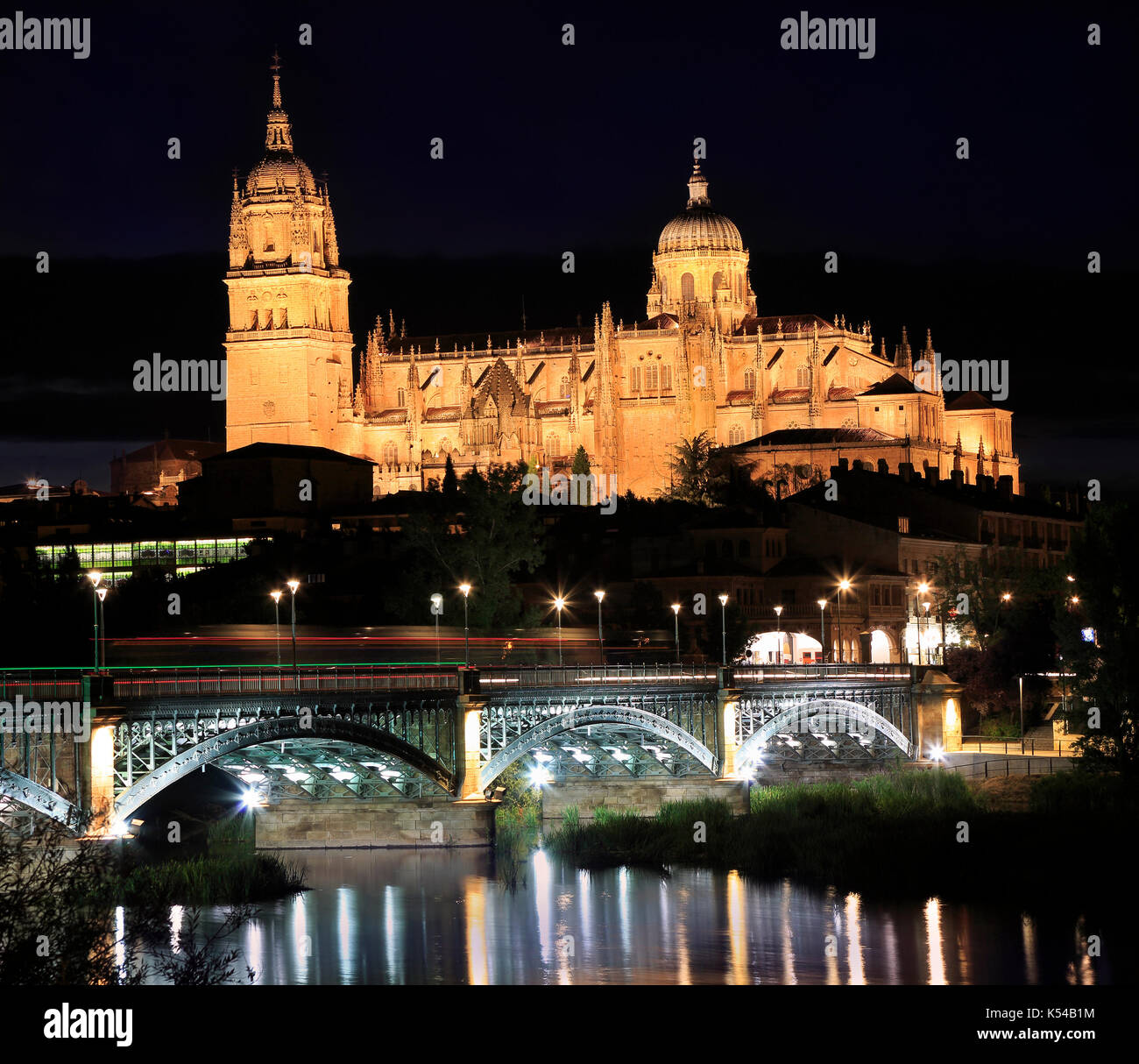 Salamanca skyline illuminated at night and Enrique Esteban Bridge over Tormes River in Spain Stock Photo