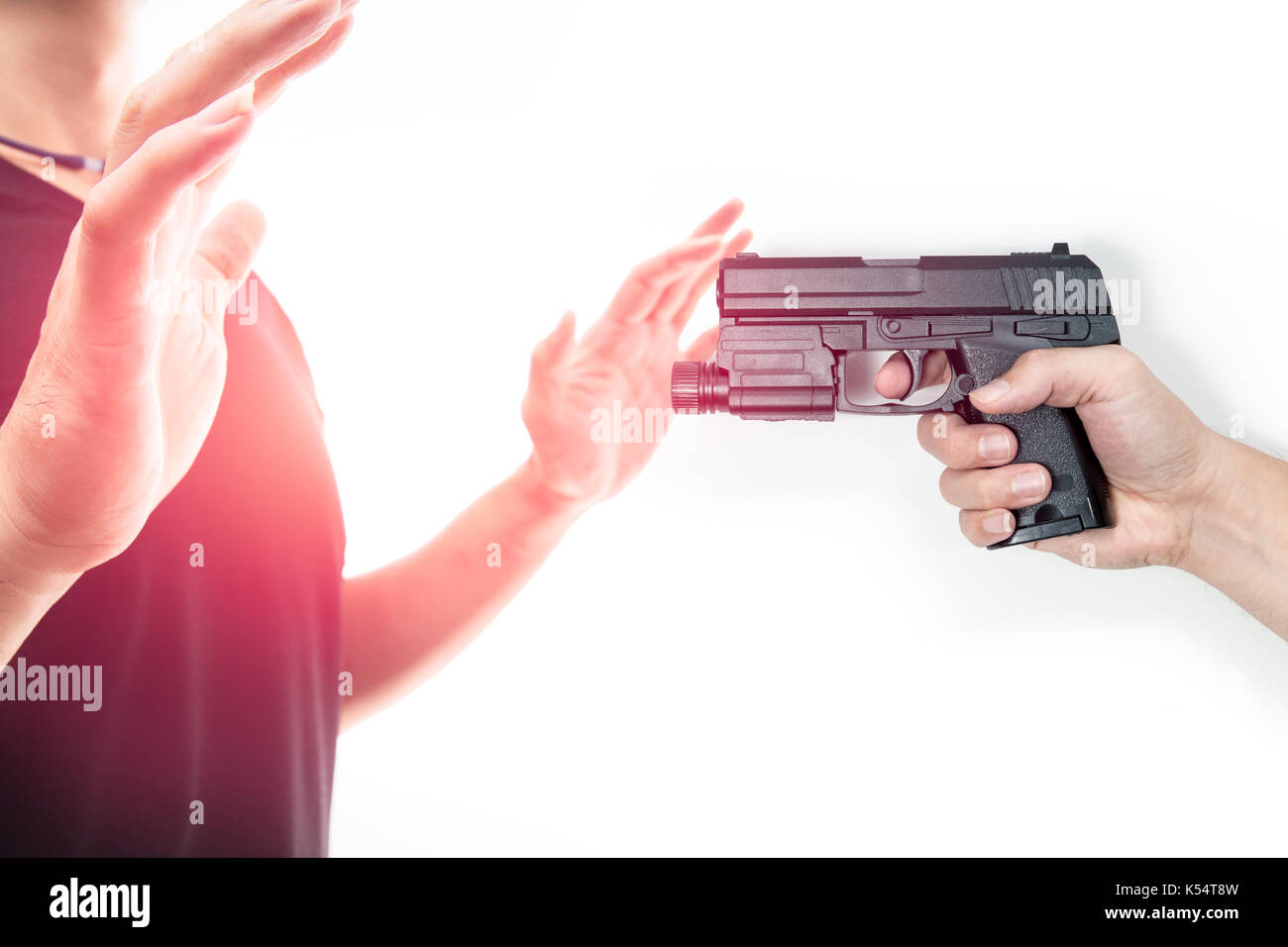 Robber with a gun robbing intimidate a man surrender. Isolated white background. Bandit steals from the male. Concept of robbery. Stock Photo