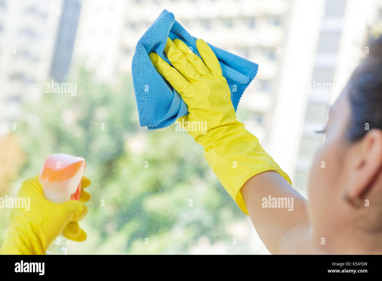 Woman cleaning window with blue cloth Stock Photo - Alamy