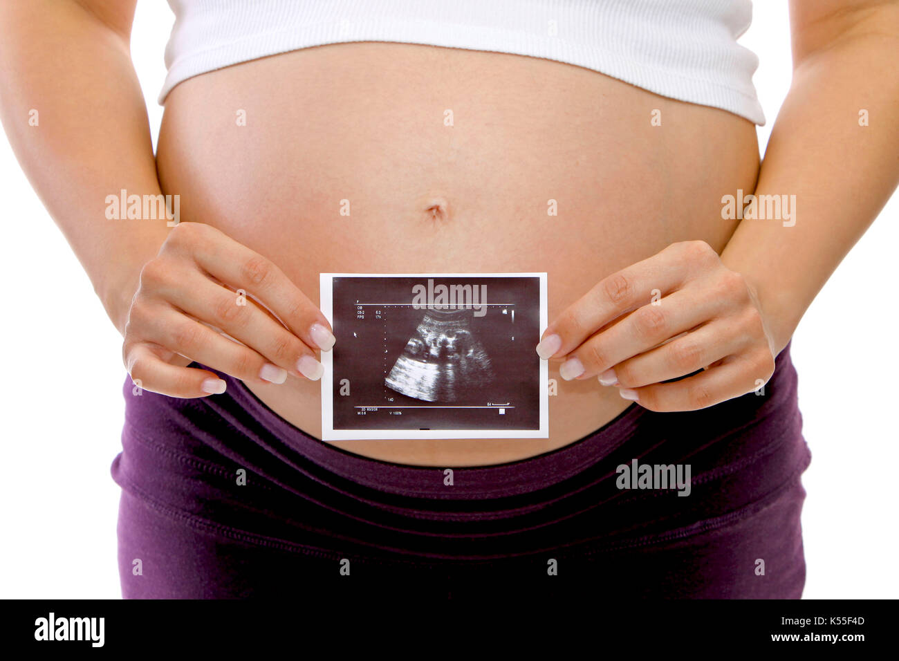 Pregnant woman holding an ultrasonic image in front of her belly Stock Photo