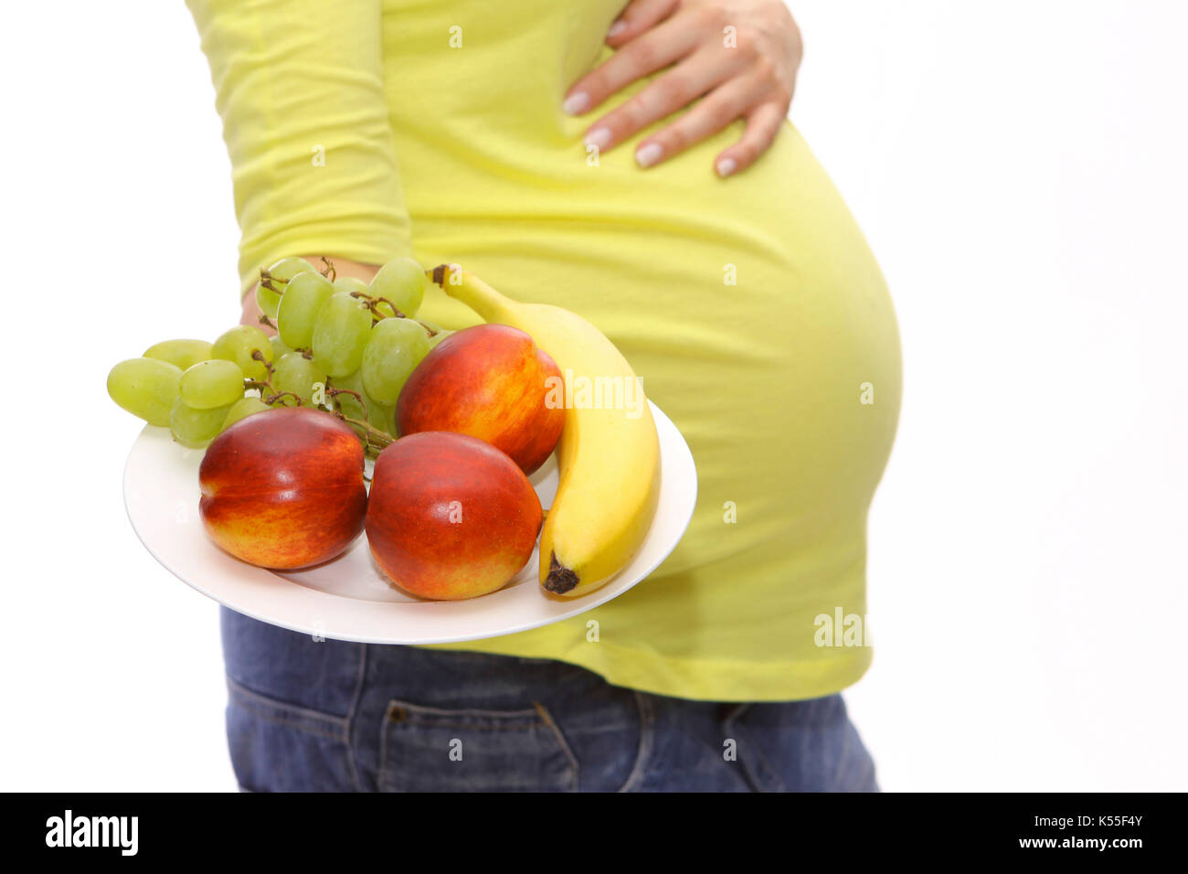 Pregnant woman with a plate of fresh fruit Stock Photo