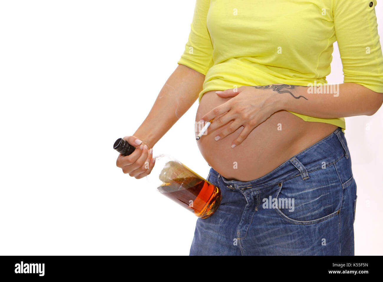 Pregnant woman with baby belly drinks alcohol and smokes a cigarette Stock Photo