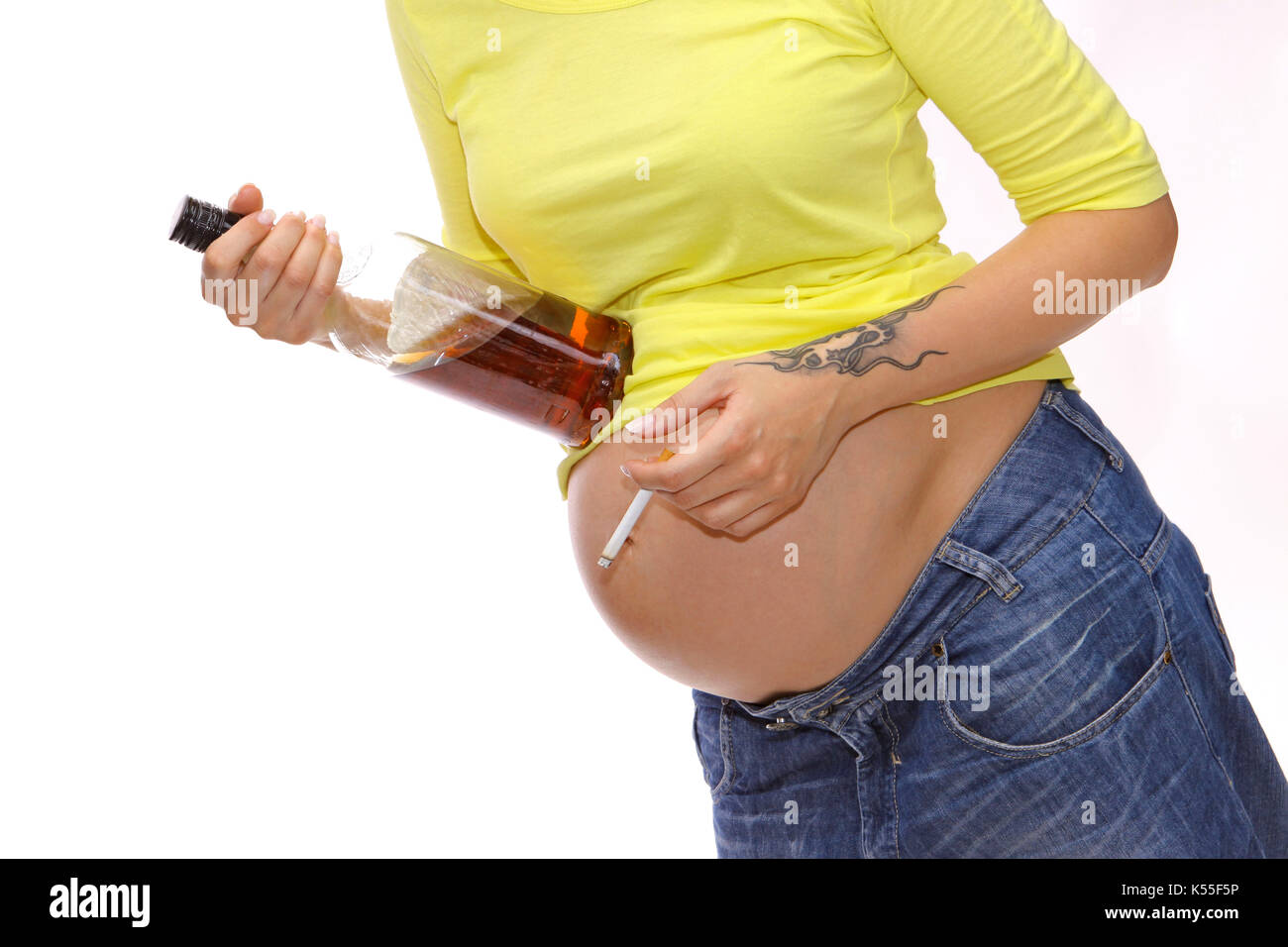 Pregnant woman with baby belly drinks alcohol and smokes a cigarette Stock Photo