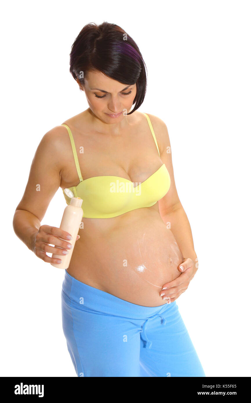 Pregnant woman applying lotion on her baby belly Stock Photo