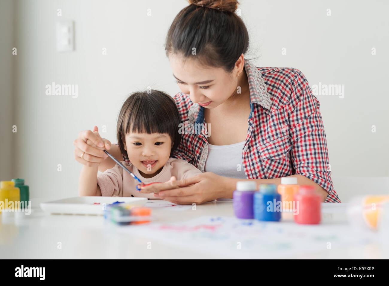 Little girl painting with her mother at home Stock Photo - Alamy