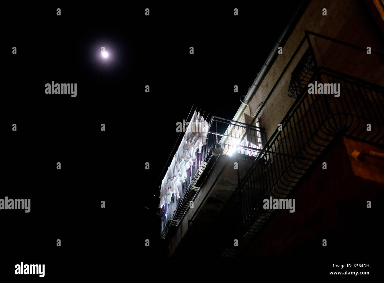 Full moon shining over white clothes on drying rack in Mea Shearim neighborhood, an ultra-Orthodox enclave in West Jerusalem Israel Stock Photo