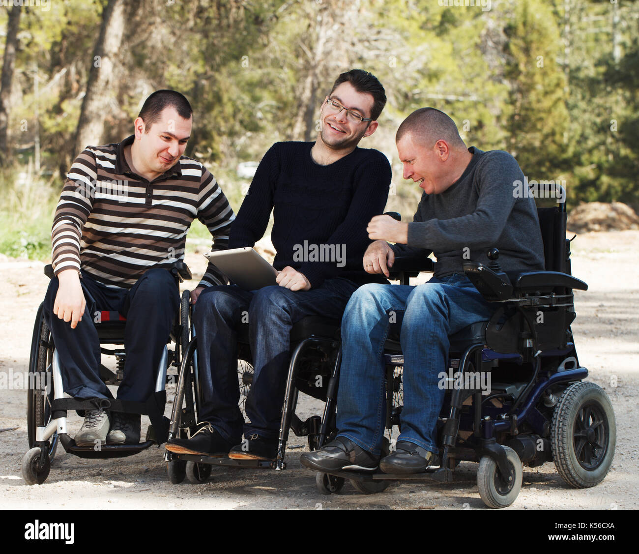 Disabled happy friends with ipad Stock Photo