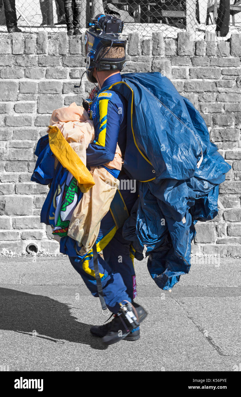 member of the Tigers Freefall Parachute Team wearing GoPro camera equipment holding parachute canopy at Bournemouth Air Festival, Dorset in August Stock Photo