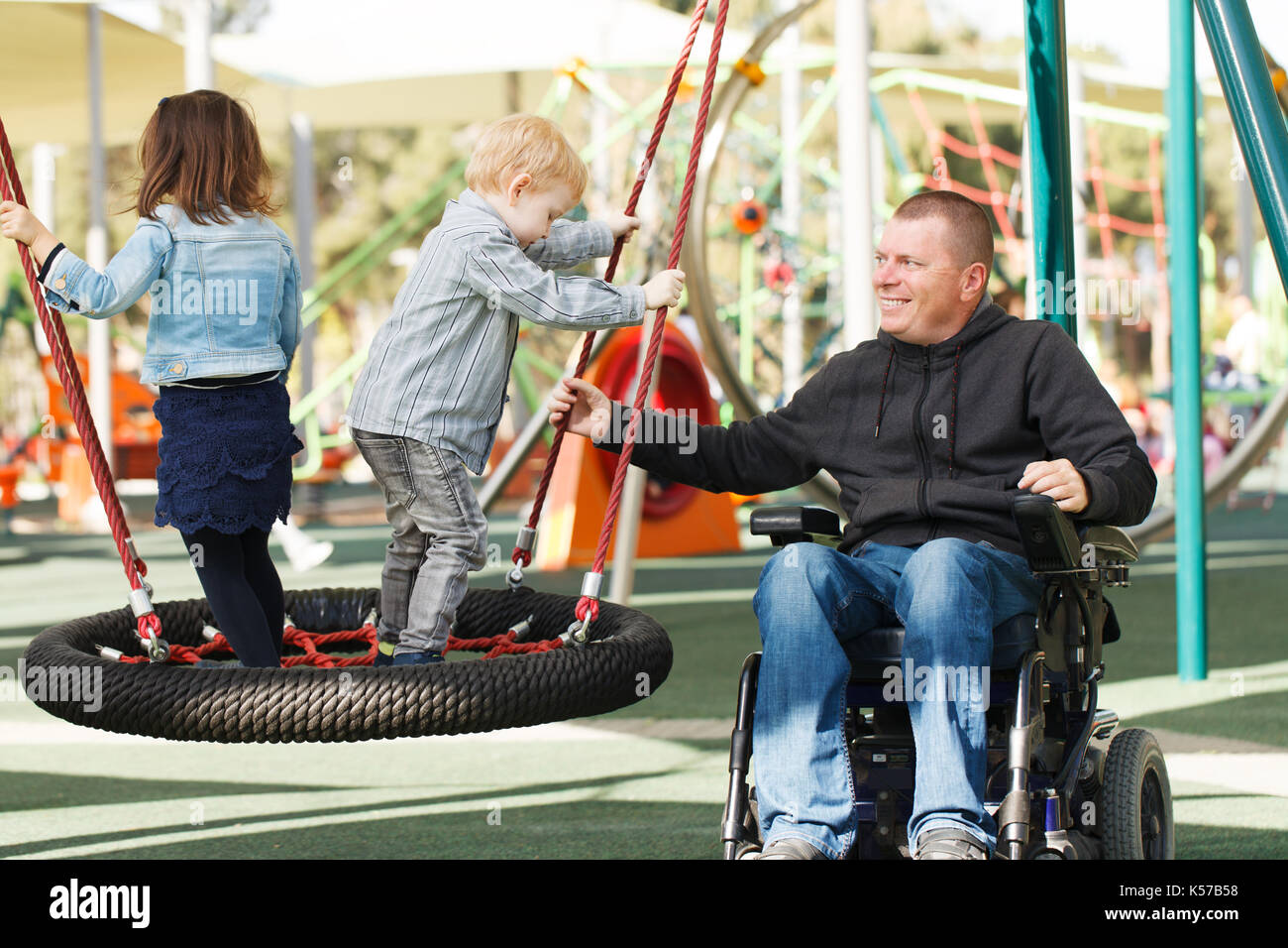 Disabled father play with his little son and daughter Stock Photo