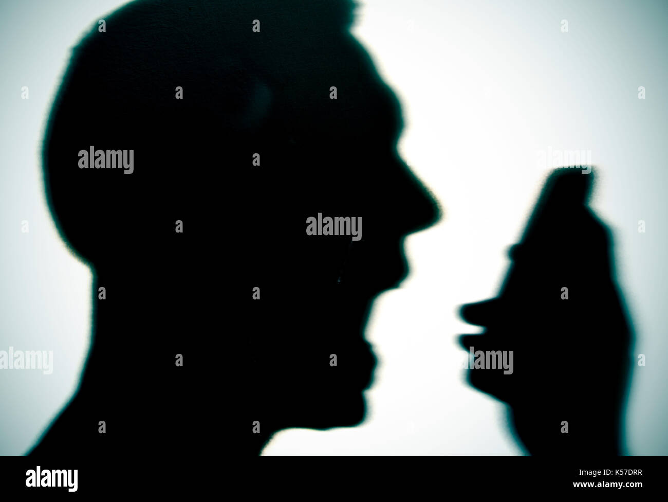 closeup of the silhouette of a young caucasian man yelling to the phone, with a dramatic effect Stock Photo