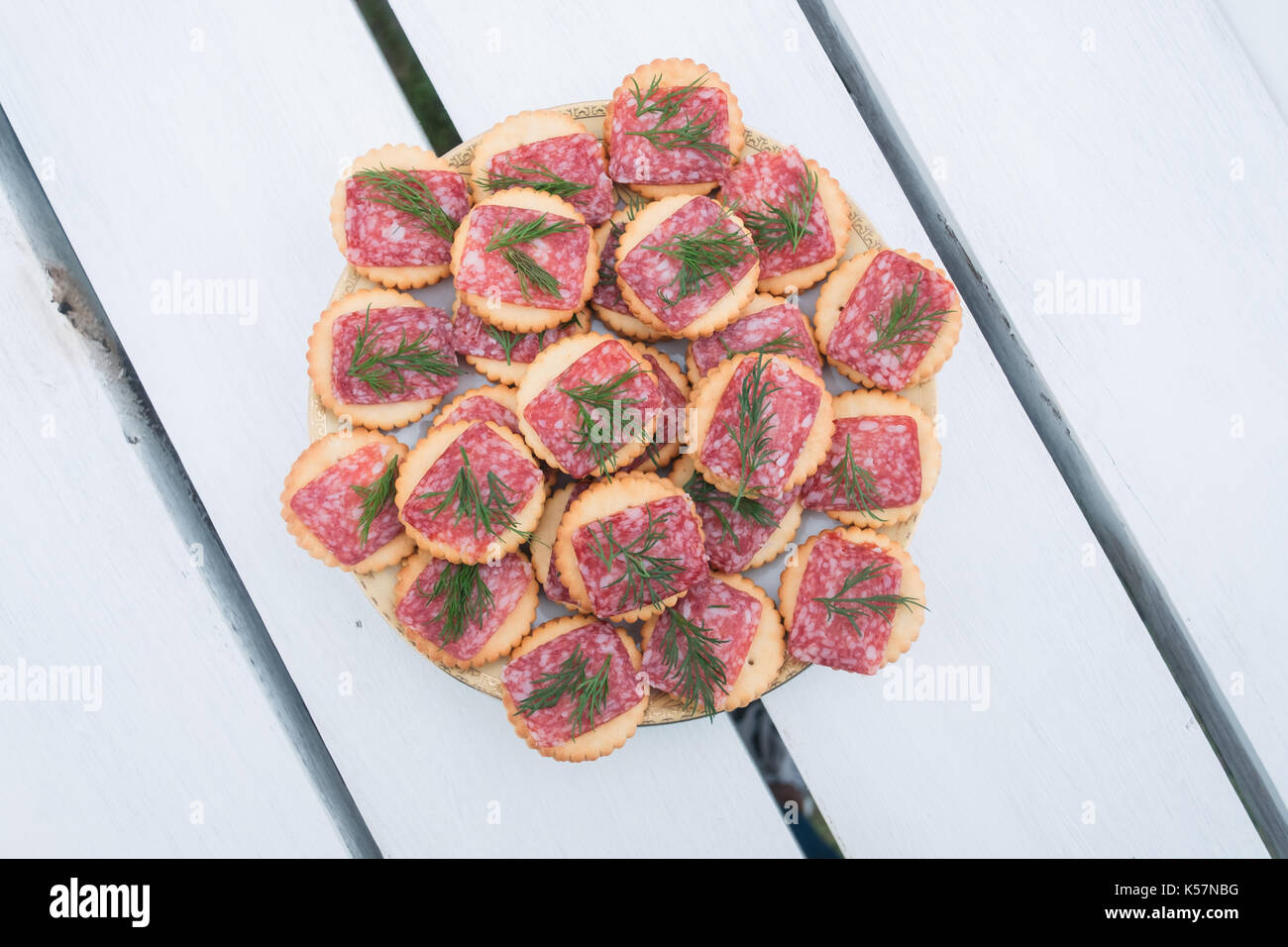 Heap of snack with salami and dill on white wood table Stock Photo