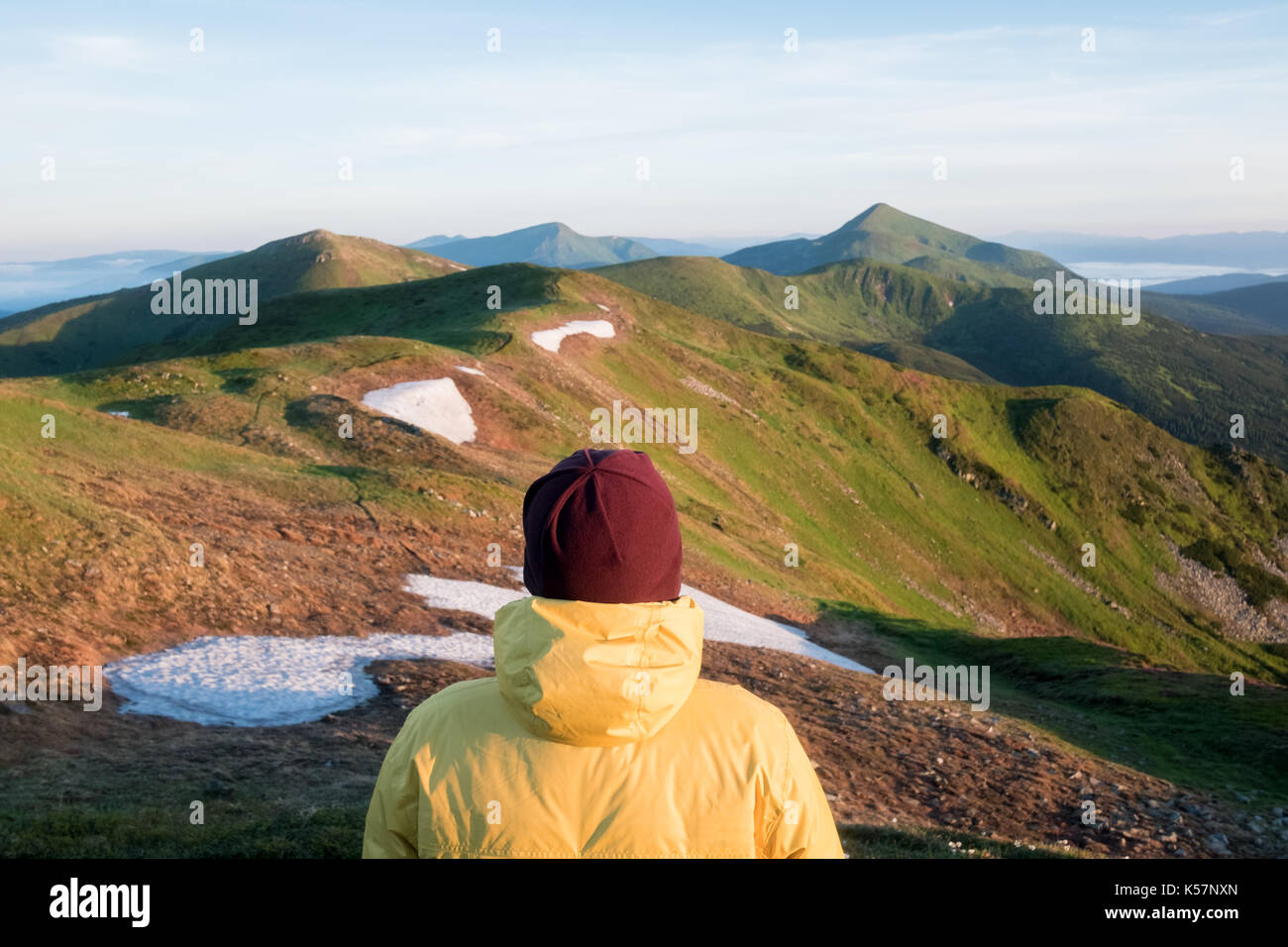 Alone tourist in yellow jacket on high mountains. Stock Photo