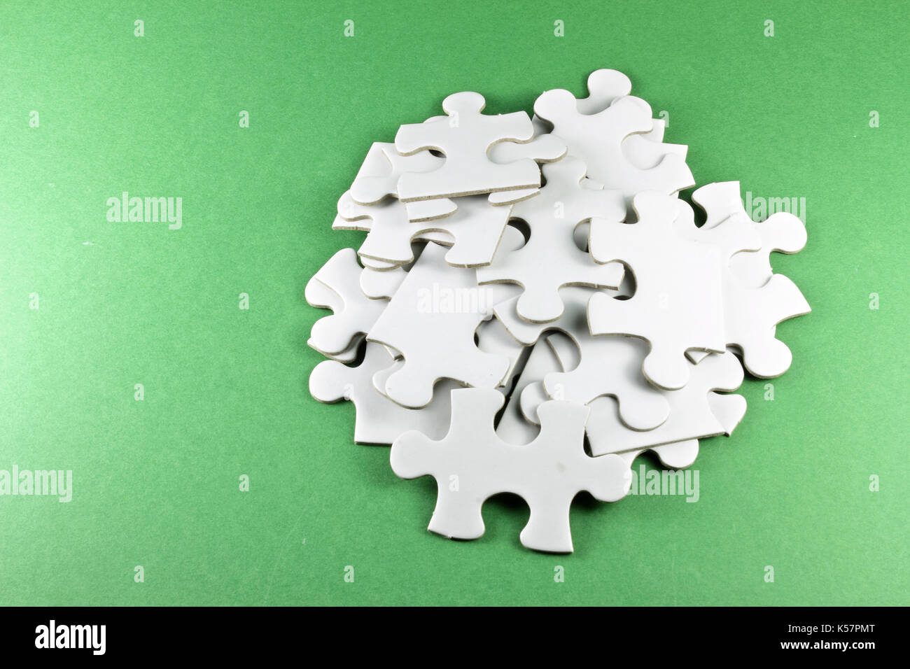Jigsaw Puzzle Pieces on Green Background Stock Photo