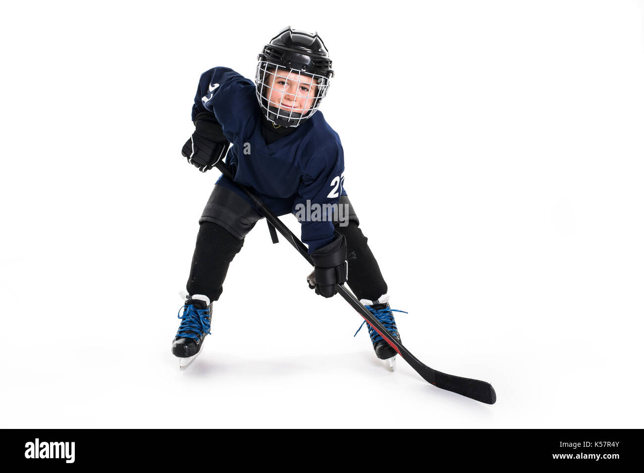 Young boy in ice hockey gear against white Stock Photo