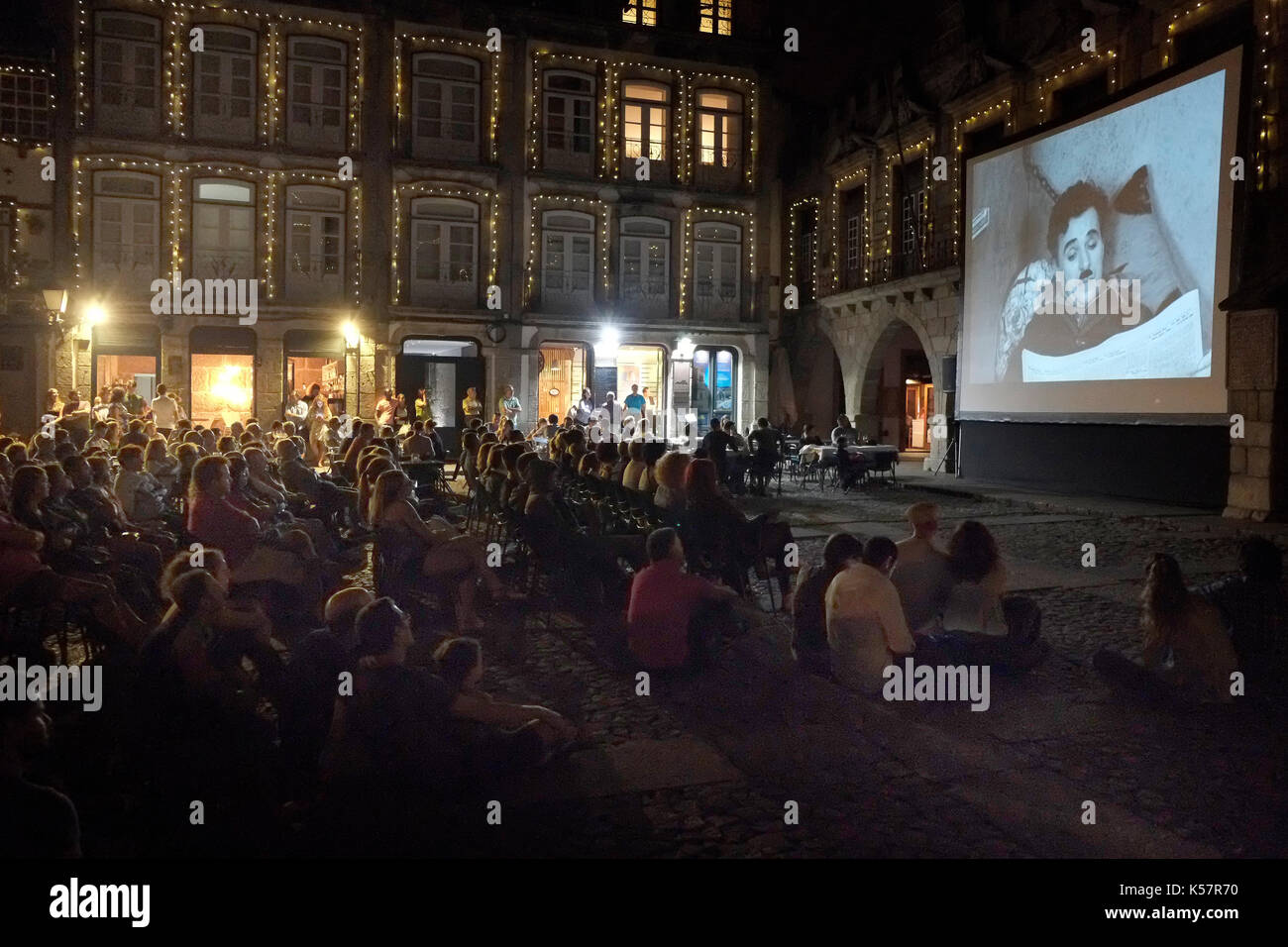 Tourists and local residents watch a free showing of a Charlie Chaplin film in the town square of Guimaraes, in Portugal August 22, 2017. © John Voos Stock Photo