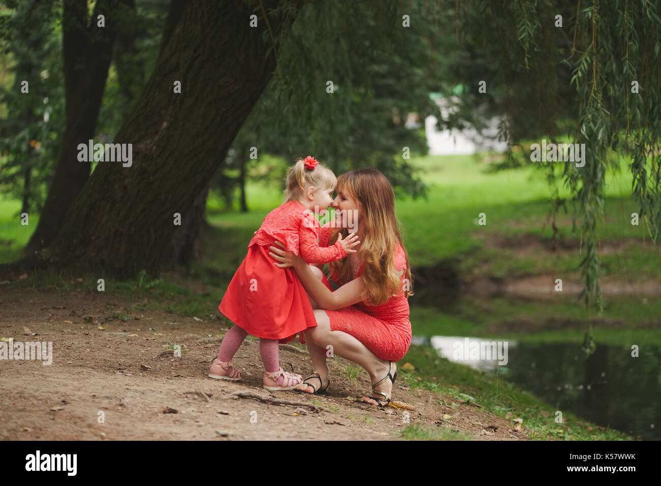 happy mother with daughter in red dresses Stock Photo