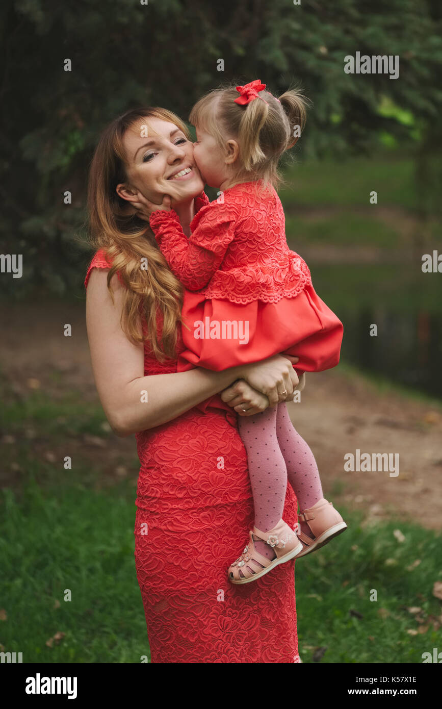 happy mother with daughter in red dresses Stock Photo