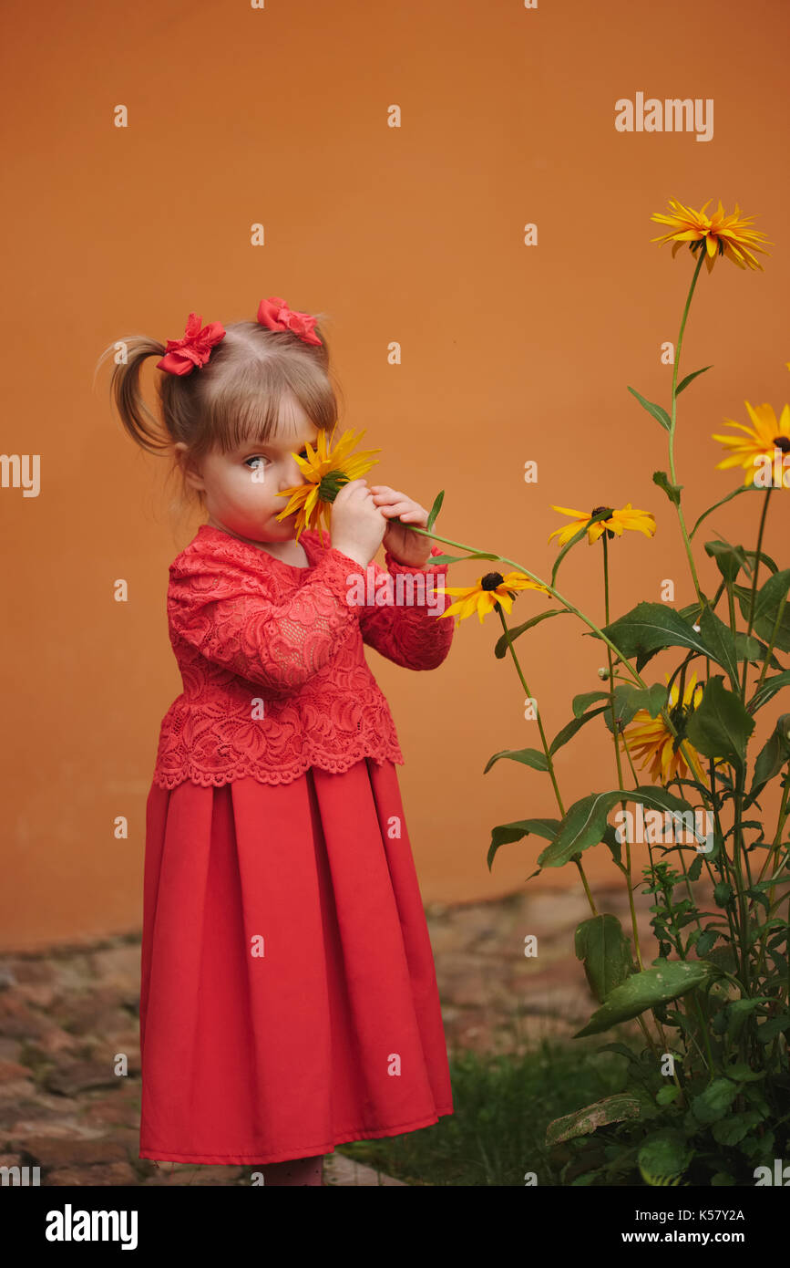 happy little girl with yellow flowers Stock Photo - Alamy