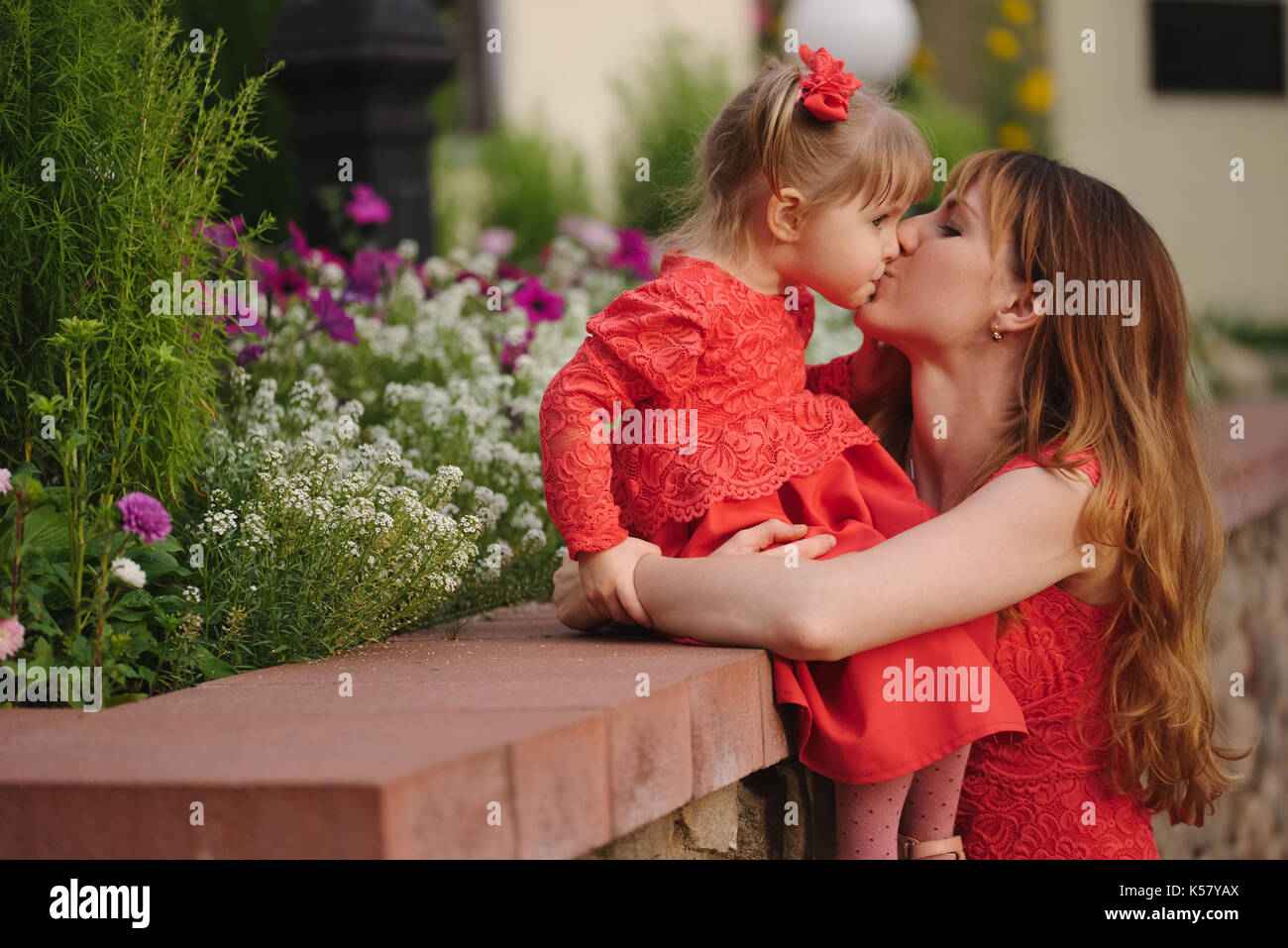 mother with daughter in red dresses in park Stock Photo
