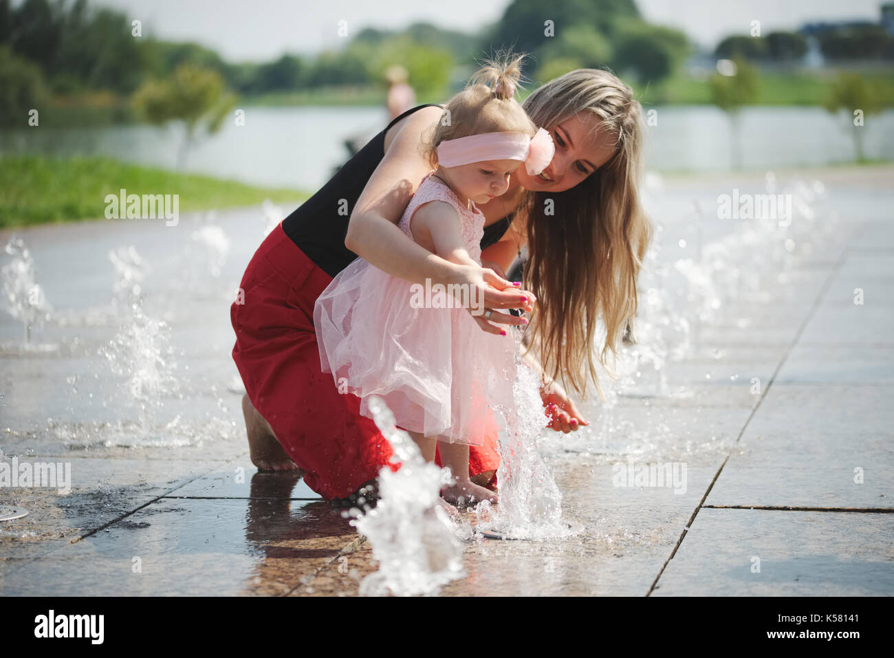young mother with daughter at fountain Stock Photo