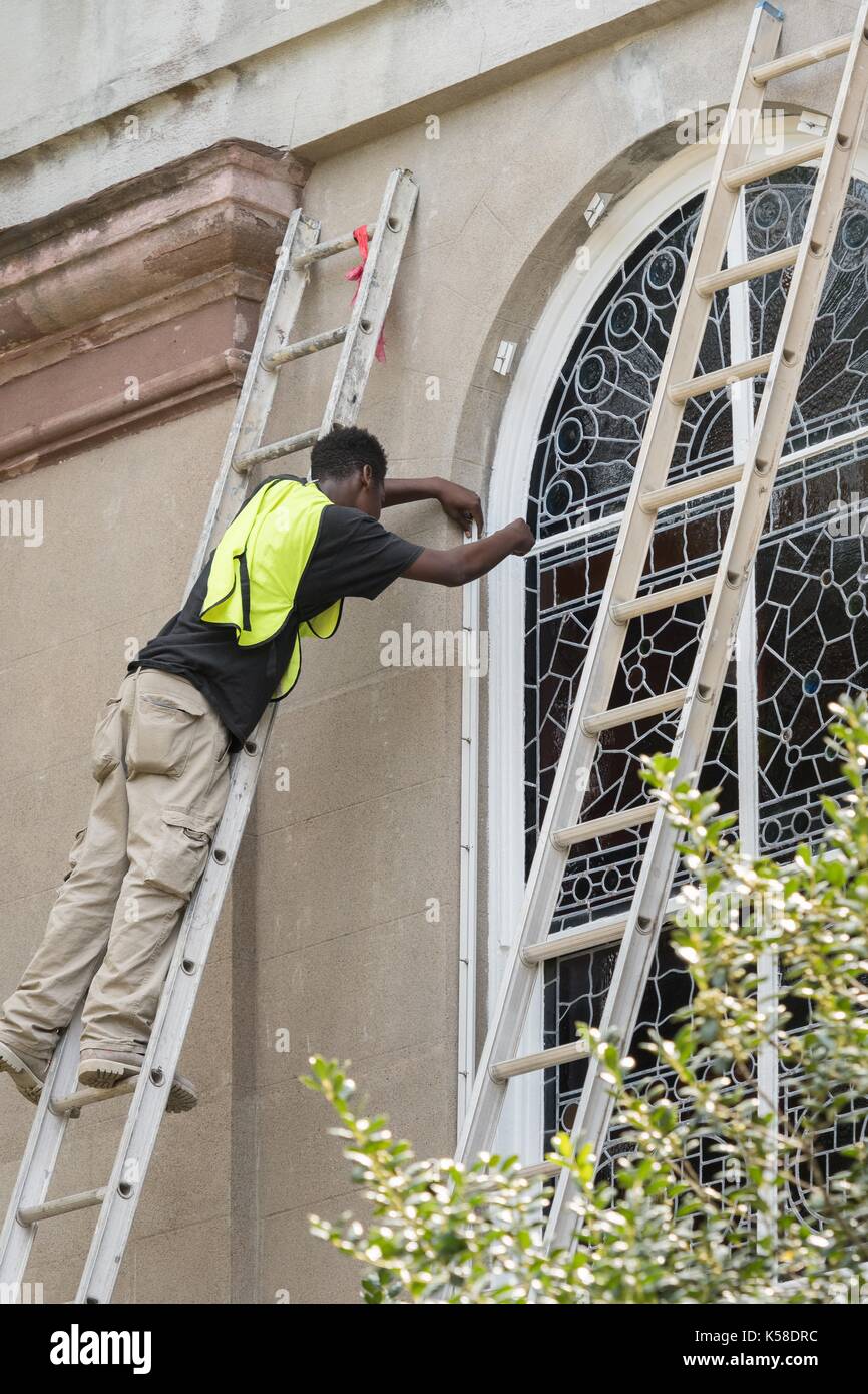 Workers secure hurricane shutters on a historic church in preparation for Hurricane Irma September 8, 2017 in Charleston, South Carolina. Imra is expected to spare the Charleston area but hurricane preparations continue as Irma leaves a path of destruction across the Caribbean. Stock Photo