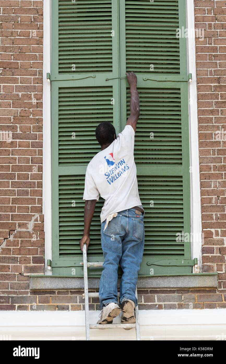 A worker secures hurricane shutters on a historic home in preparation for Hurricane Irma on the Battery September 8, 2017 in Charleston, South Carolina. Imra is expected to spare the Charleston area but hurricane preparations continue as Irma leaves a path of destruction across the Caribbean. Stock Photo