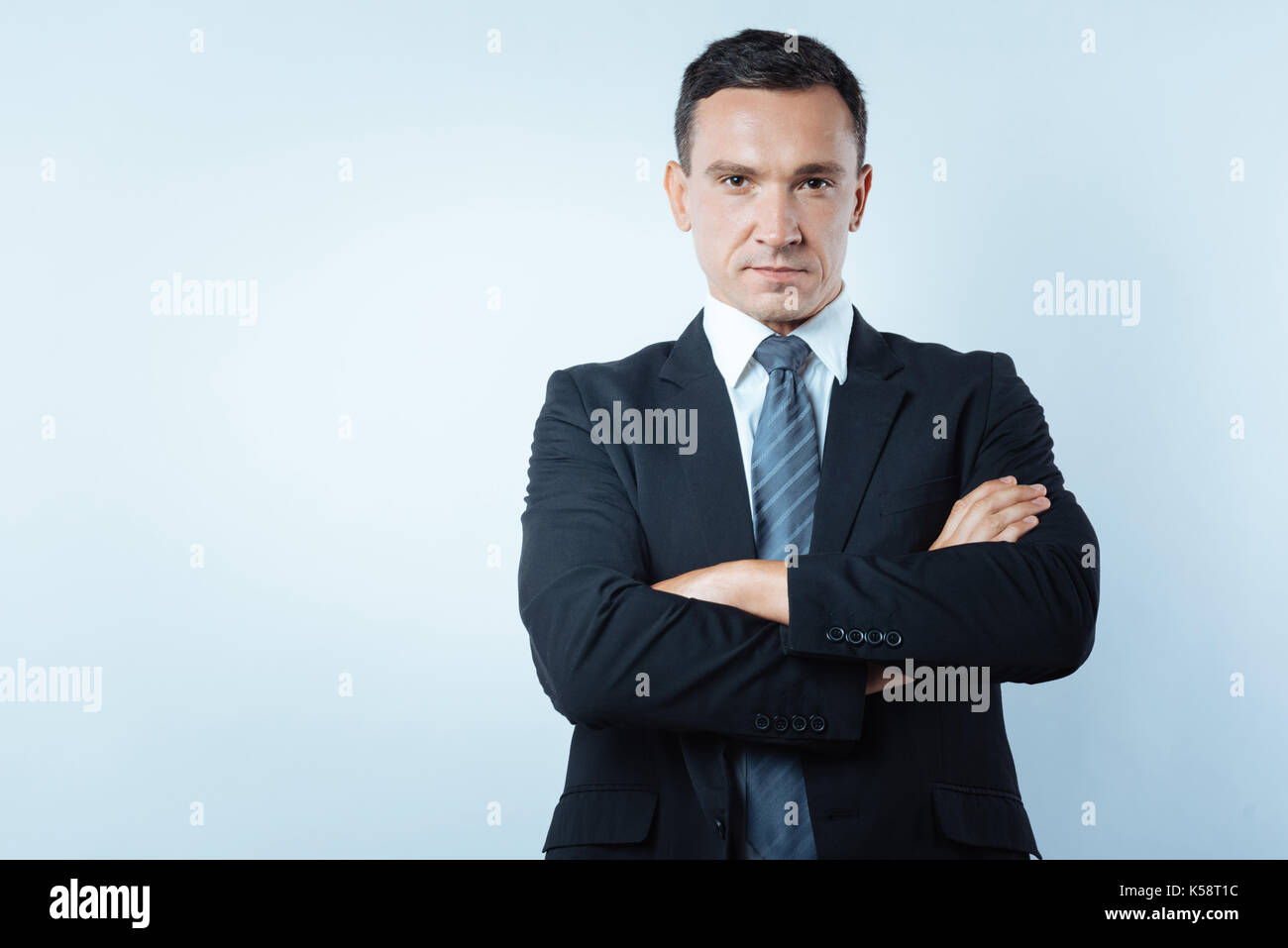 Serious confident man standing cross armed Stock Photo