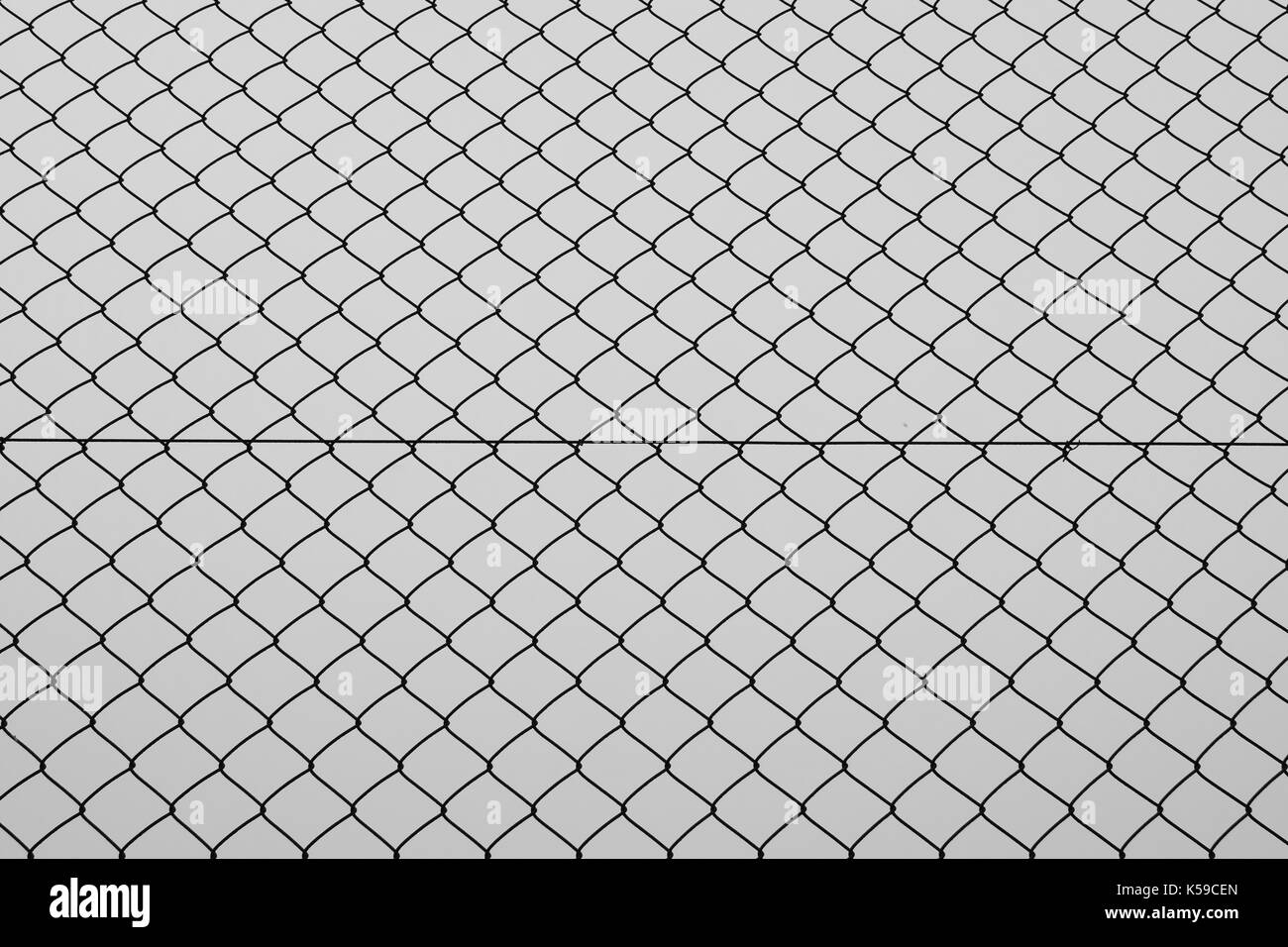 Chain link fencing iron wire mesh silhouette background texture. Abstract pattern black and white. Stock Photo