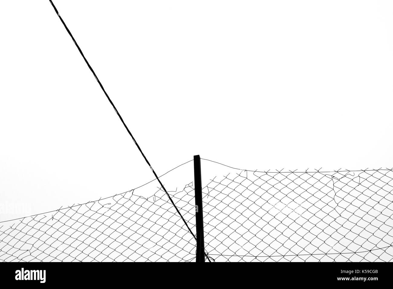 Rusty chain link fence silhouette and cable abstract background. Black and white. Stock Photo