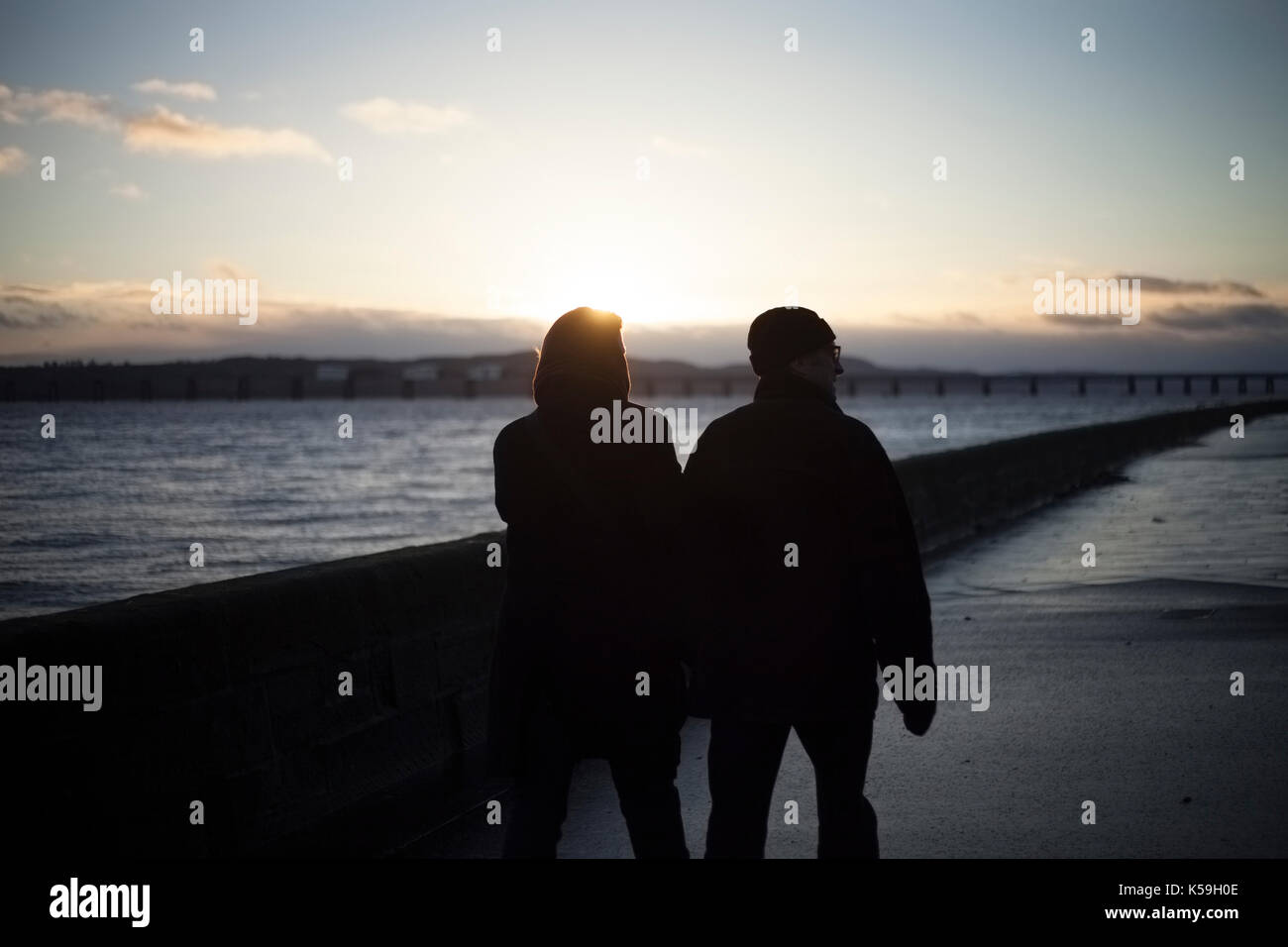 Couple holding hands, walking beside the River Tay, Broughty Ferry, Dundee, Scotland Stock Photo