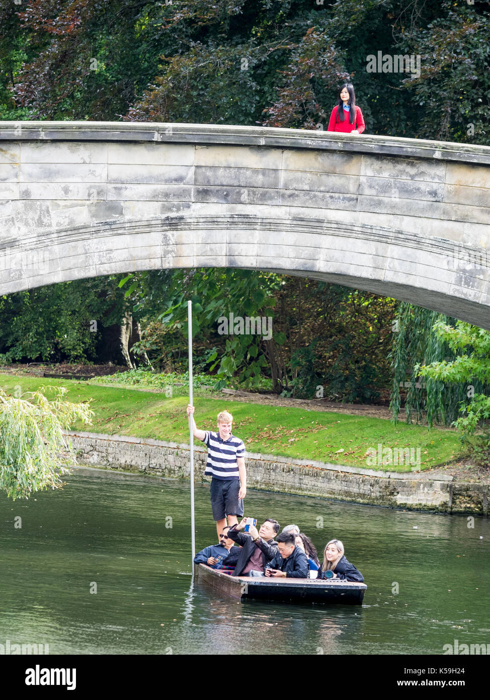 Cambridge - Tourists punt under a bridge in Kings College, University of Cambridge Stock Photo
